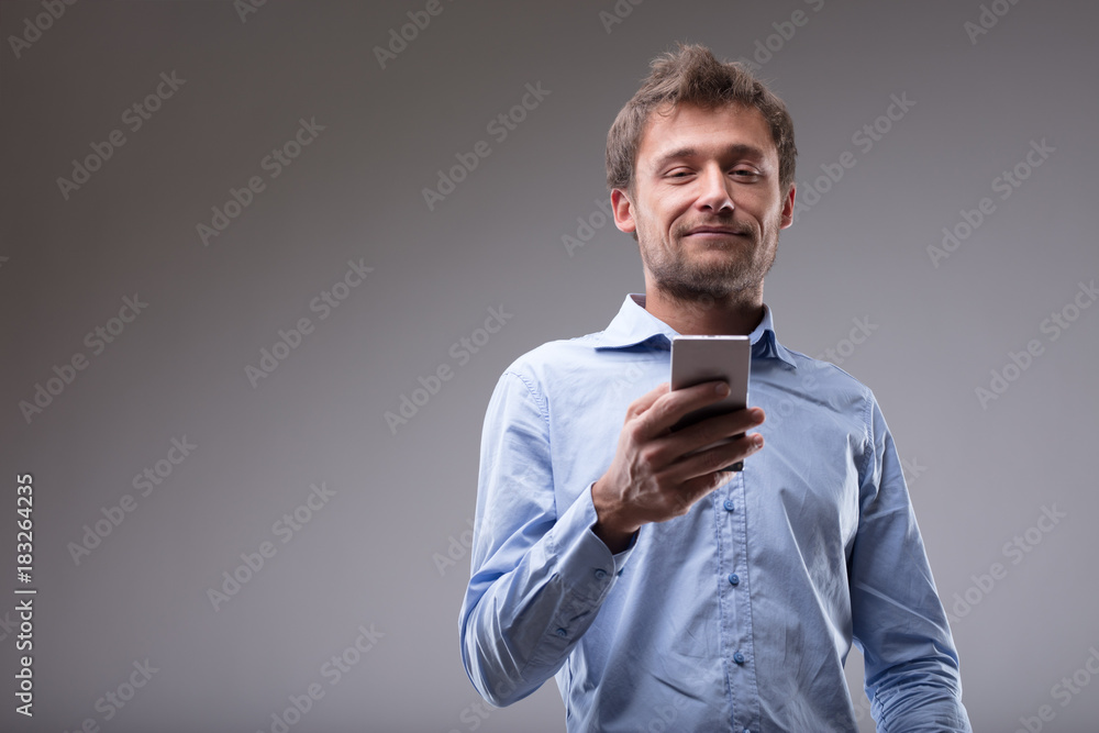 Young man reading a text message on his cellphone Young man reading a text message on his cellphone