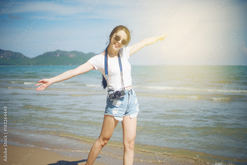 portrait of asian young teenager woman. chill out at the beach with blue sea and blue sky. wearing a sunglasses. filtered image. selective focus. light effect added. happy summer travel concept portrait of asian young teenager woman. chill out at the beach with blue sea and blue sky. wearing a sunglasses. filtered image. selective focus. light effect added. happy summer travel concept