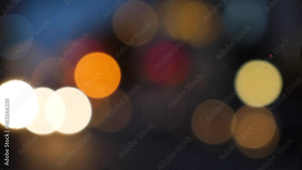 A nighttime bokeh view of traffic in a small city. A nighttime bokeh view of traffic in a small city.