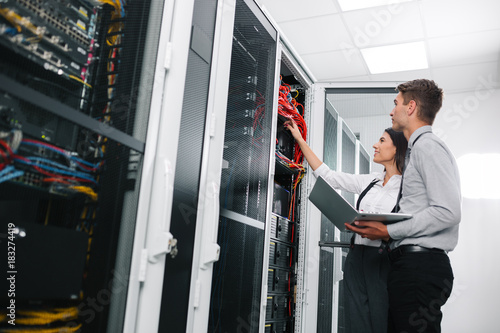 Team of technicians working together on servers at the data centre