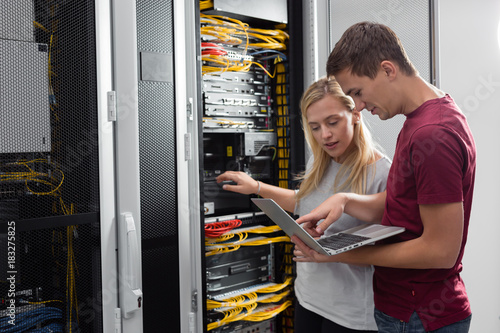 Team of technicians working together on servers at the data centre