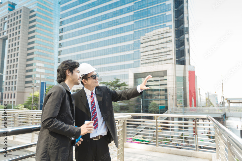 Young Engineers and Business man walking and discussing about construction project in the city. Young Engineers and Business man walking and discussing about construction project in the city.
