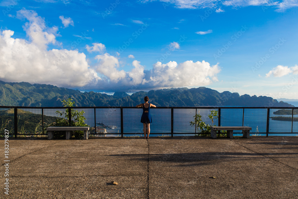 backview of girl, staying in the middle of Coron city view point with sea and blue sky on the background backview of girl, staying in the middle of Coron city view point with sea and blue sky on the background