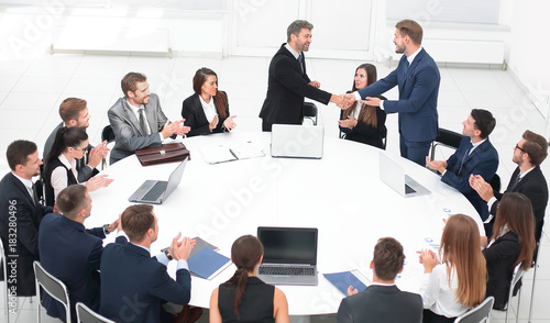 business partners shake hands at the talks near the round table