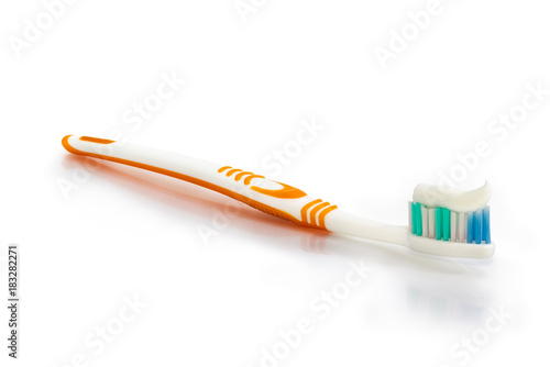 Toothbrush with toothpaste on white surface