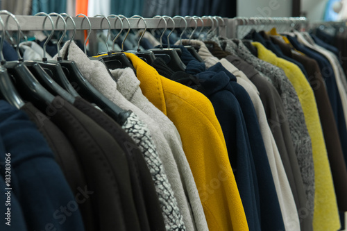 Row of autumn coats hanging on rack, shopping