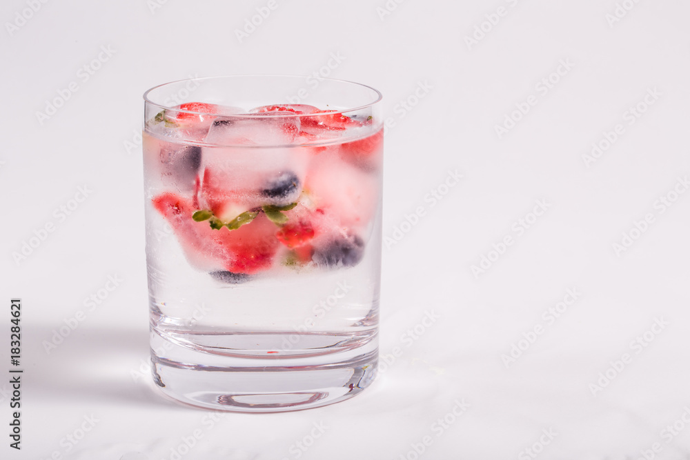 Ice berries in glass of water Ice berries in glass of water