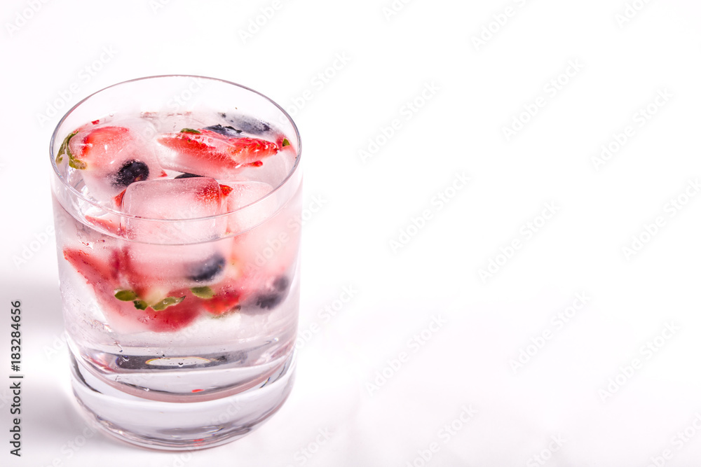 Ice berries in glass of water Ice berries in glass of water