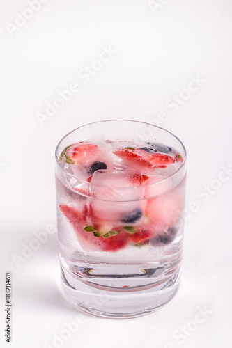 Ice berries in glass of water