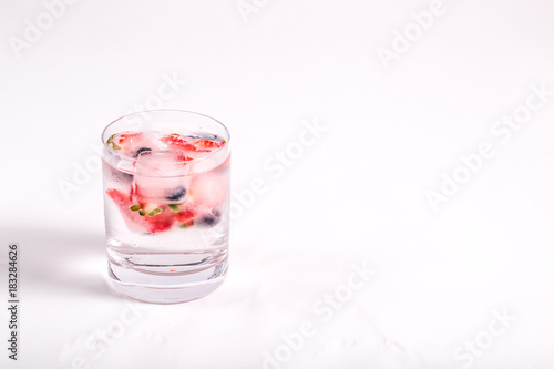 Ice berries in glass of water