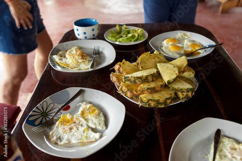 Breakfast table with fried eggs and fruits