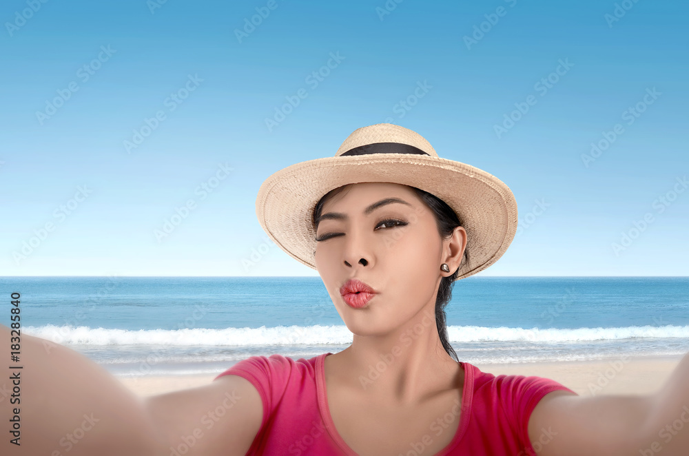 Beautiful asian woman in hat doing selfie