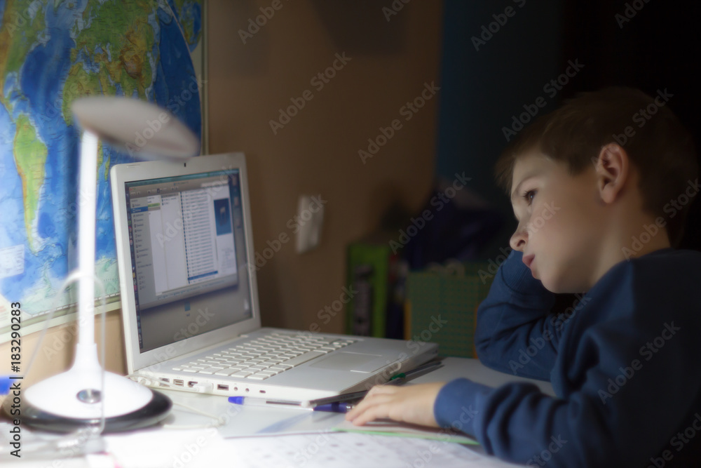 Tired boy doesn't want to do homework on laptop and notebook Tired boy doesn't want to do homework on laptop and notebook