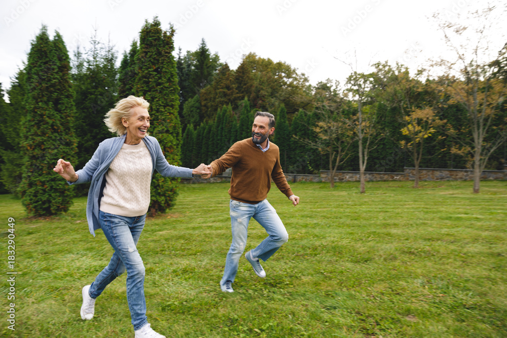 Cheerful mature couple holding hands