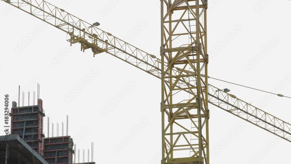 View of crane laying concrete partitions between floors of multi-storey building View of crane laying concrete partitions between floors of multi-storey building