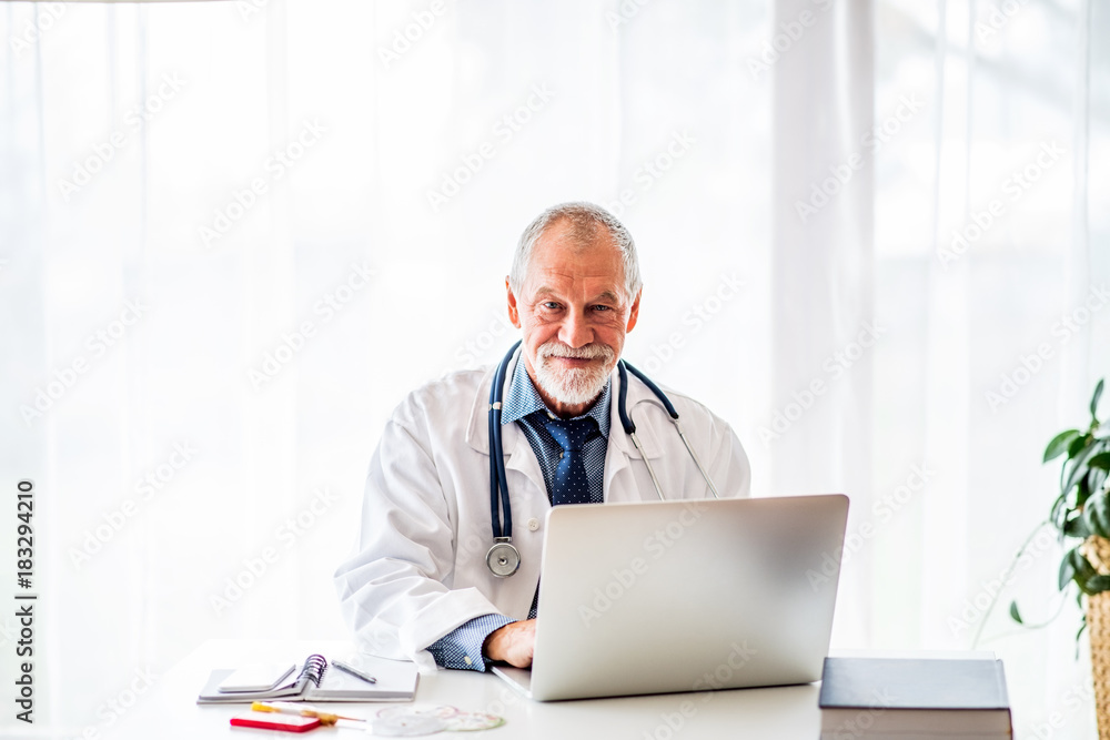 Senior doctor with laptop working at the office desk. Senior doctor with laptop working at the office desk.