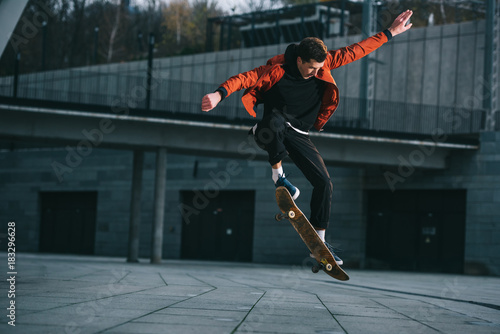 Skateboarder doing jump trick in urban location photo