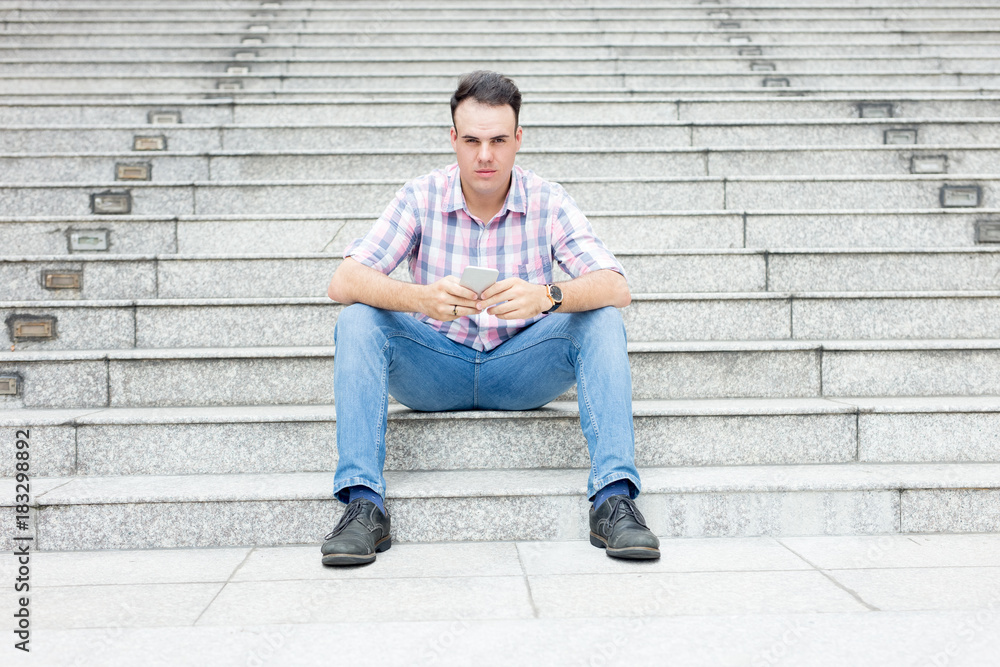 Serious Man Using Smartphone on City Stairway Serious Man Using Smartphone on City Stairway