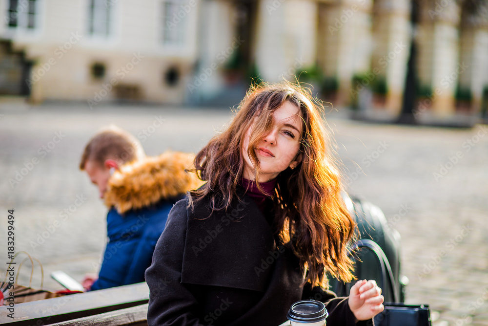 Happy girl with long hair drinks coffee at the table Happy girl with long hair drinks coffee at the table