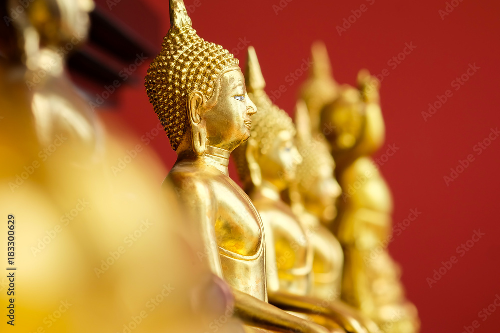 Fototapeta premium Golden Buddha On a red background with selective focus