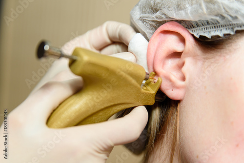 Ear piercing in the beauty salon. photo