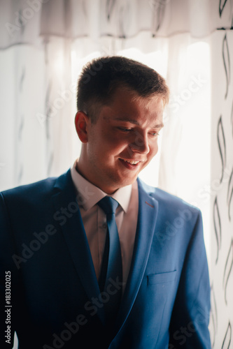 portrait of the groom on a light background