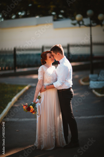 groom and the bride against the trees of the park photo