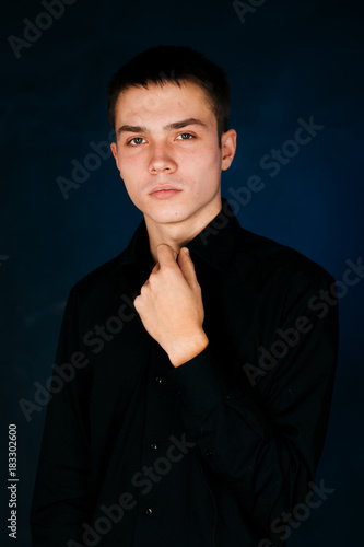 young guy on a dark studio background