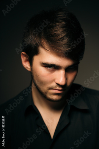 young brunette guy on a dark background