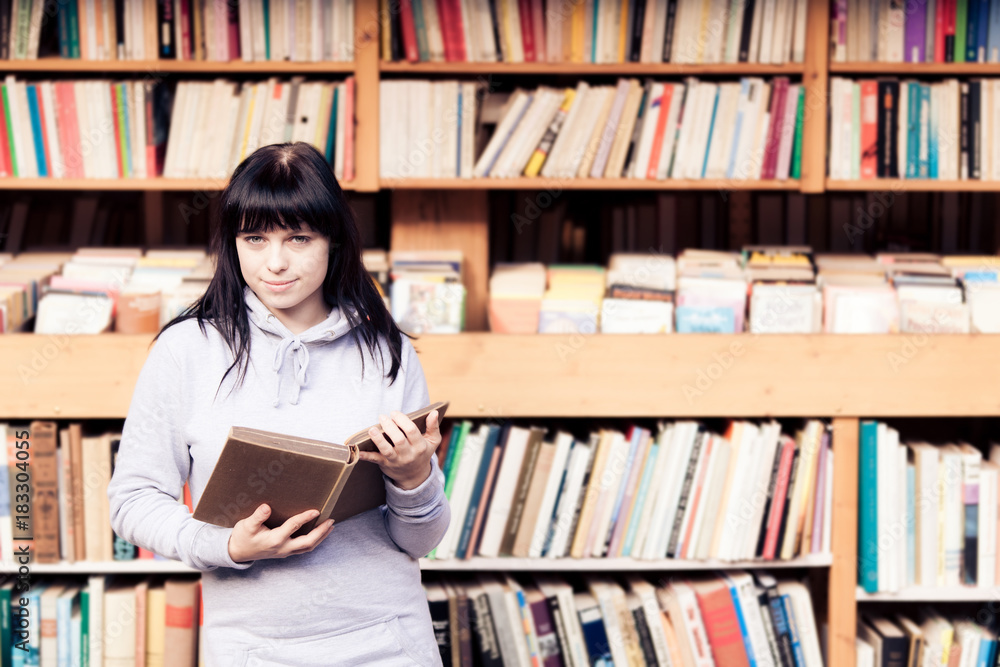 Young Woman Looking At Books In A Bookstore Young Woman Looking At Books In A Bookstore
