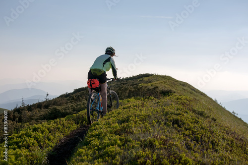 Woman rides bicycle up in the mountains