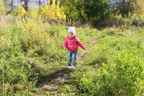 Lovely smiling 1 years girl walking in autumn outdoors