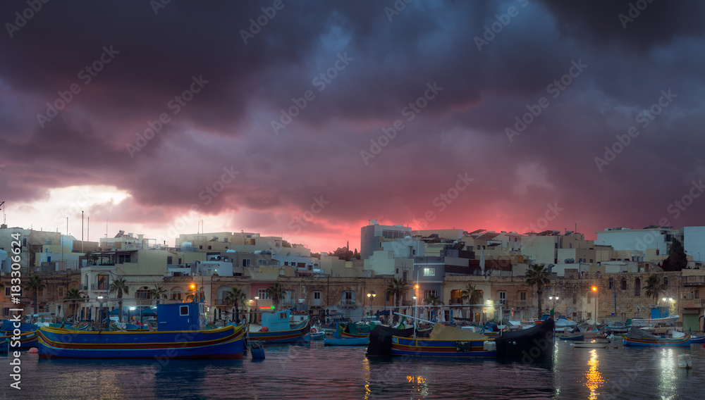 Gloomy sunset at fishing village Marsaxlokk, Malta
