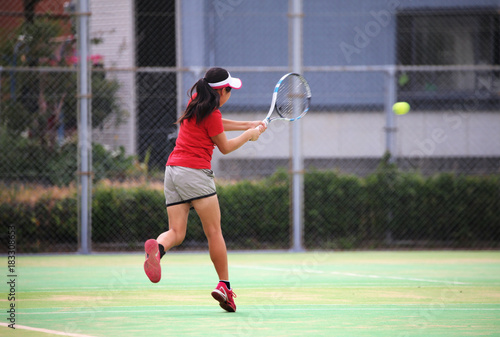 テニスでバックハンドを打つ女の子