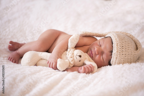 image of a newborn brazilian baby curled sleeping in a blanket