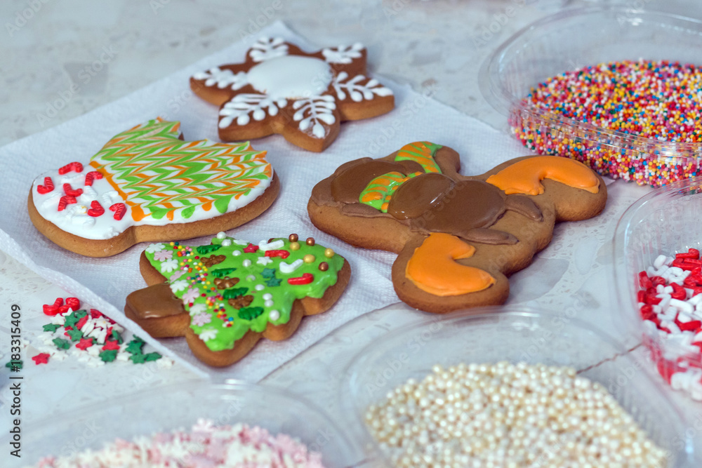 Handmade cookies in the form of a mitten, a Christmas tree, a snowman and a snowflake. Four gingerbread and confectionery decorations. New Year Treats.