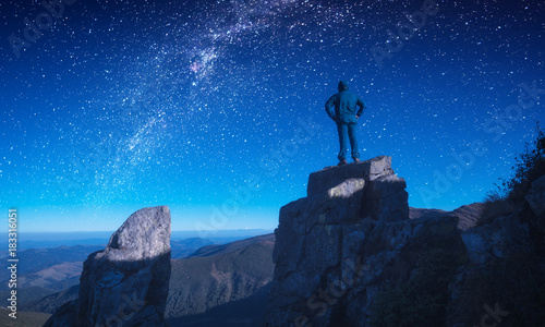 Man standing on a edge against night sky
