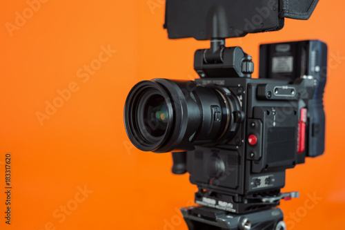 Professional video camera on vivid color background making contrast