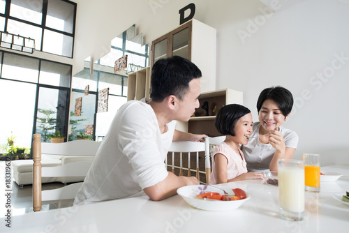 Young Asian family eating together at home.