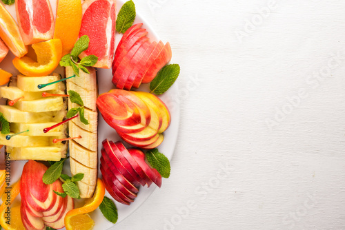 Fruit Slicing. Oranges, grapefruit, banana, mandarin, kiwi. Tagliateli. Free space for your text. Top view. photo