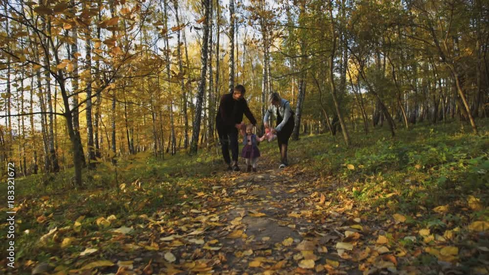 Lovely parents with their little daughter running in autumn park. 4K Lovely parents with their little daughter running in autumn park. 4K