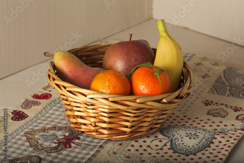 Cesto di frutta con mandarini, pera, mela e banana