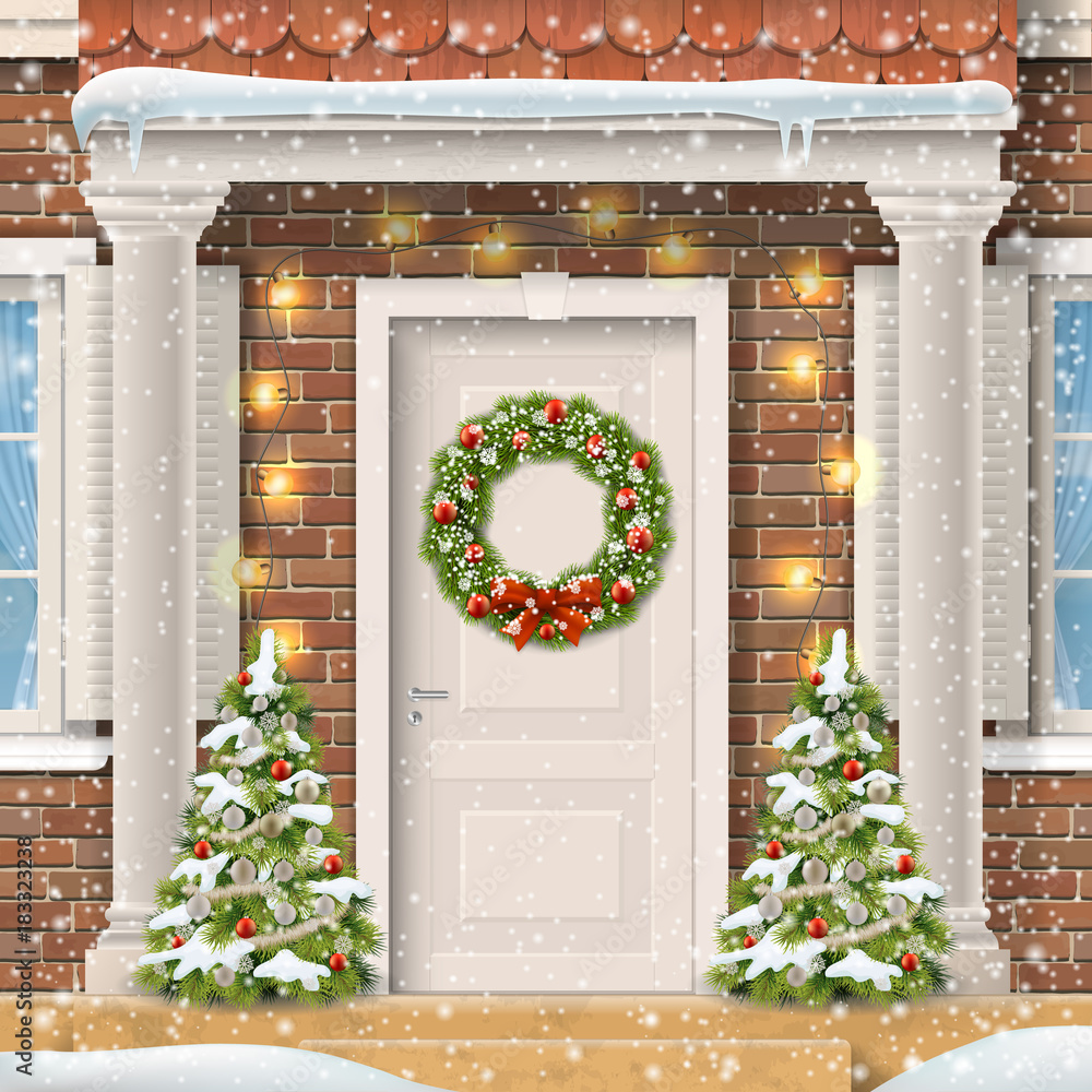 Φωτογραφία Entrance to the suburban house decorated with a Christmas wreath on the door with a garland and spruce