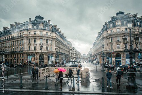 Fototapeta Naklejka Na Ścianę i Meble -  People under colored umbrellas run in the rain on the streets of Paris, France