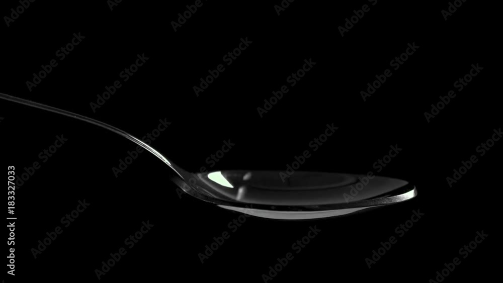 white salt falling down into a spoon, slow motion white salt falling down into a spoon, slow motion