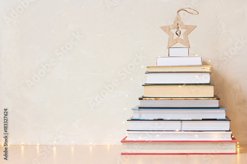Christmas background with a pile of books and a wooden star