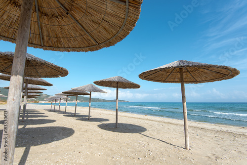 Sarty  Greece  Summer beach without people  sea and sand  empty sea and beach background with straw umbrellas