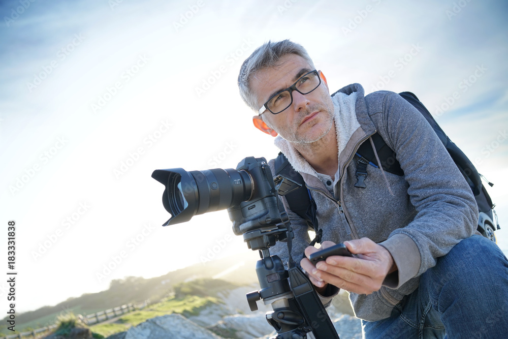 Obraz premium Photographer using wifi device to look at photo shots