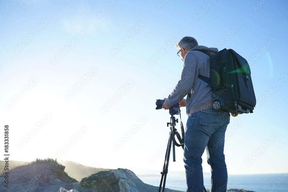 Photographer using tripod to take pictures of landscape