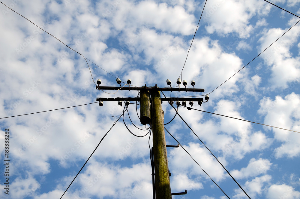 Electricity pole on the background of the sky with clouds